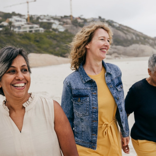 Can NAD+ Help With Perimenopause? A group of women walking on the beach, smiling