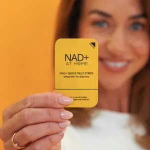 Close-up of a hand holding an NAD+ Quick Melt Strips sachet, 100mg NAD+ per strip